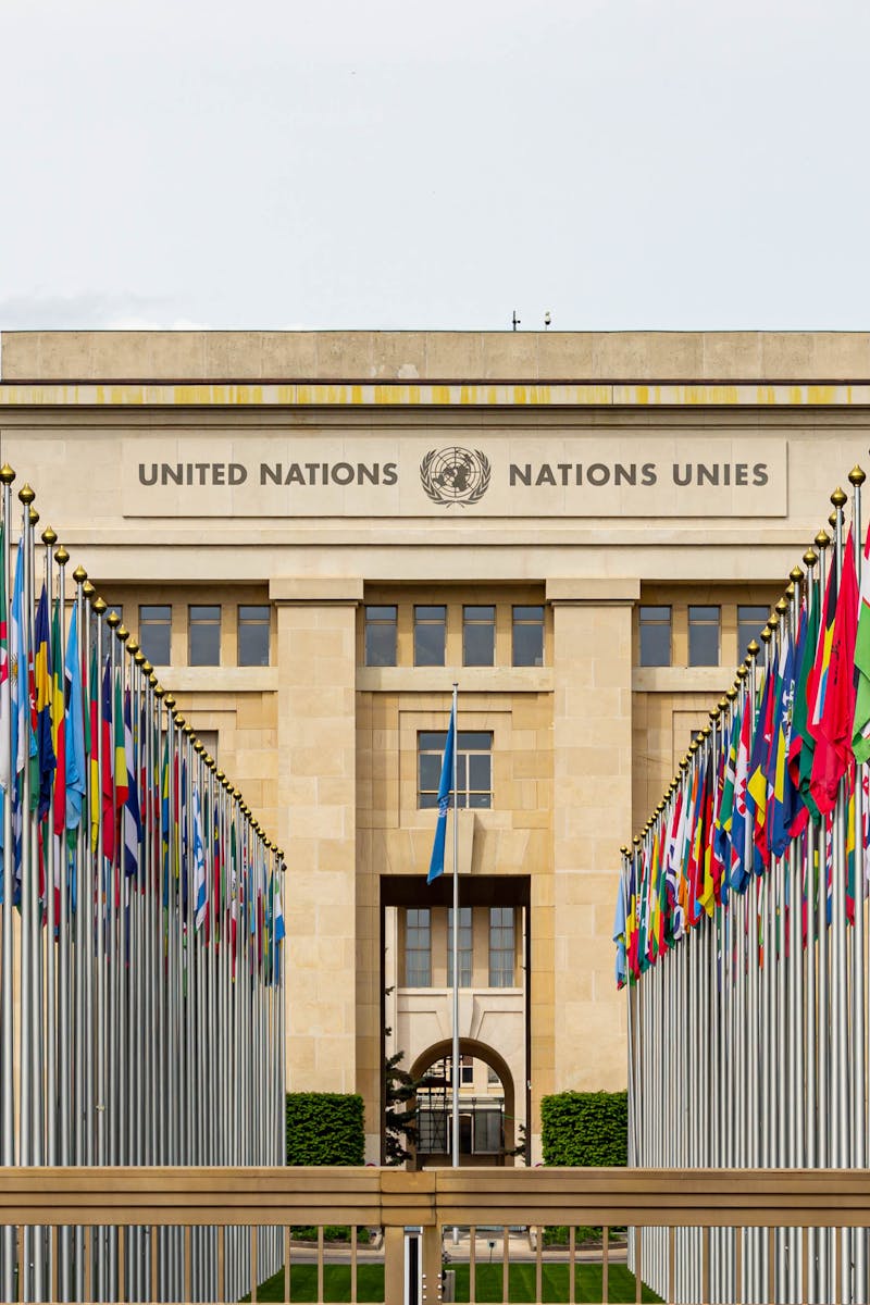 View of the United Nations Office in Geneva adorned with flags of various countries.