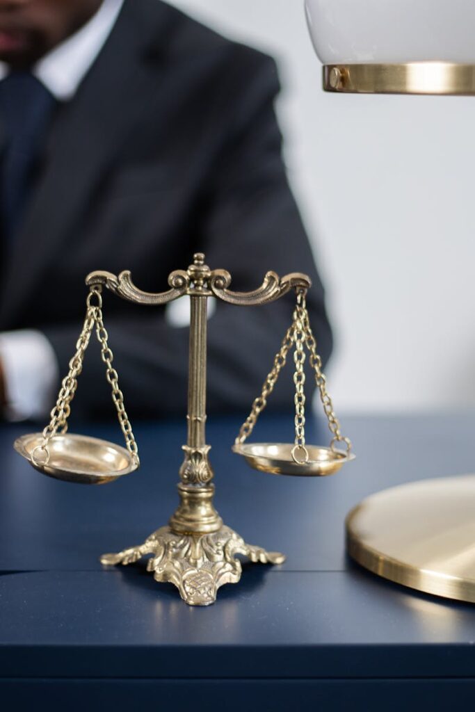 Elegant legal office with a close-up of golden scales of justice on a sleek dark desk.