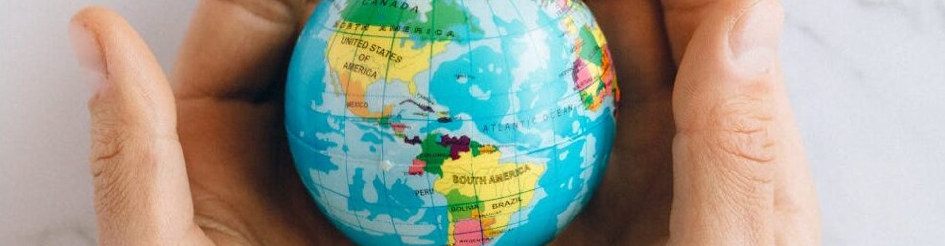 pexels-photo-7235805-7235805 Close-up of hands gently holding a small globe representing global unity and care.